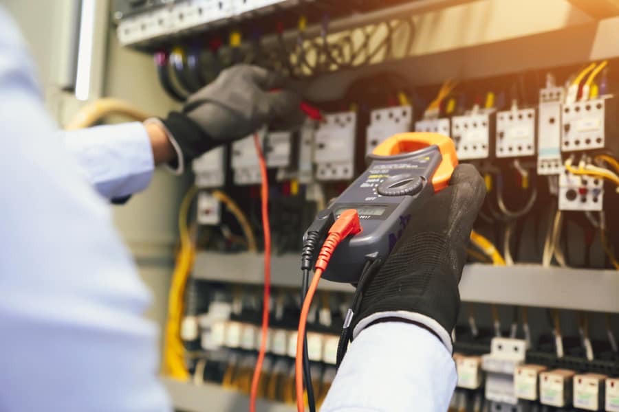 Electrical Engineer Using Digital Multi-Meter To Check Current Voltage At Circuit Breaker