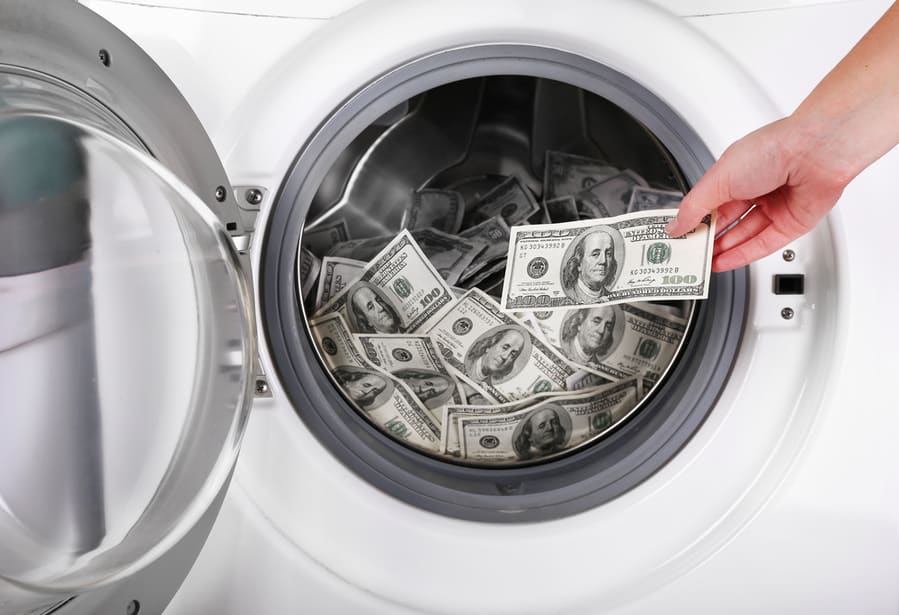 Female Putting Money Into Washing Machine
