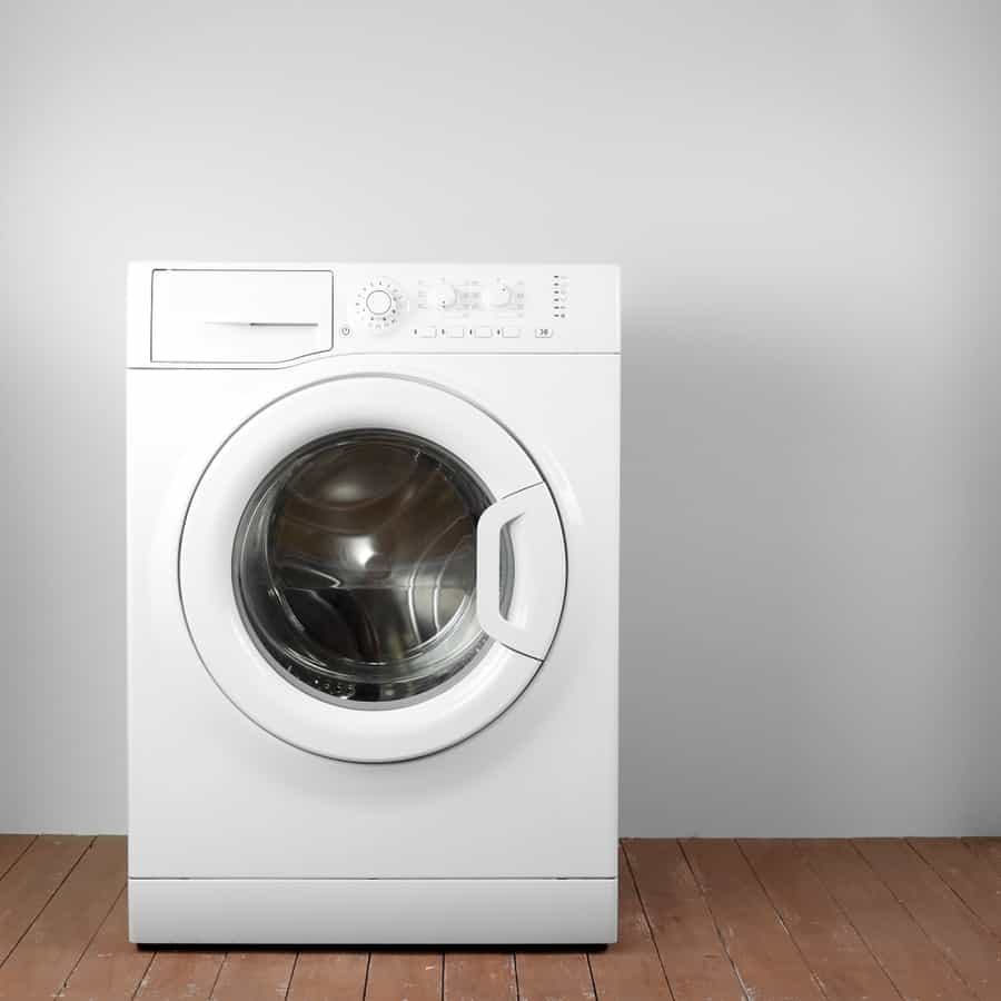 Front View Close Door Washing Machine On A White And Wood Background