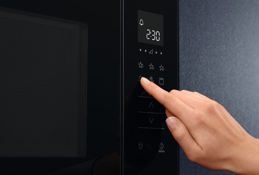 Hand Pressing The Button On The Microwave Oven