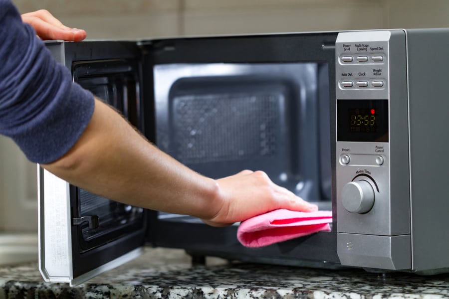 Housewife Cleaning Microwave Oven