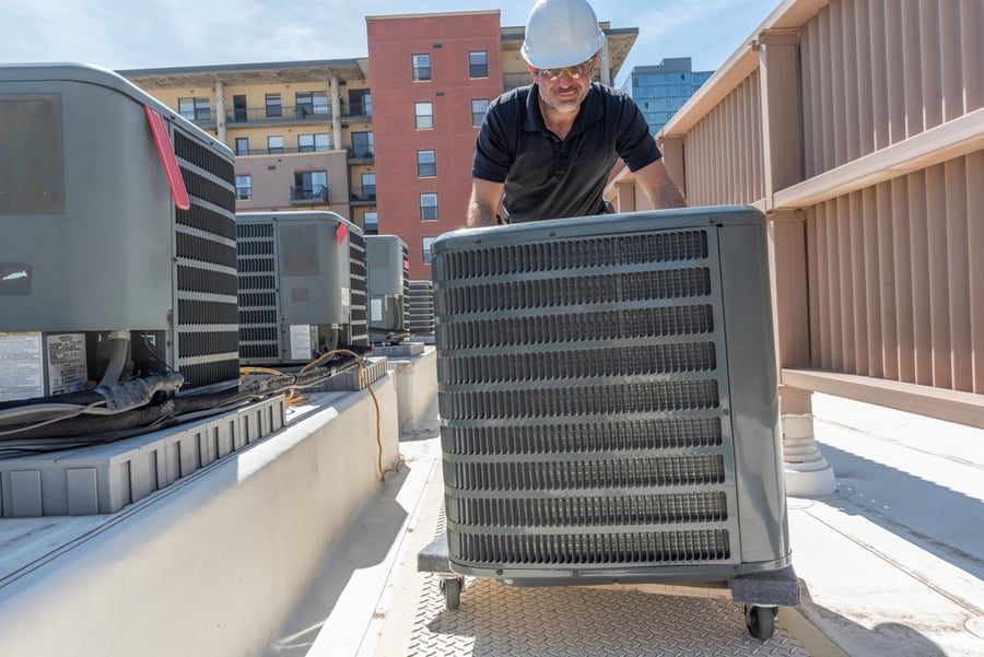 Hvac Technician Rolling A New Air Conditioner For An Install