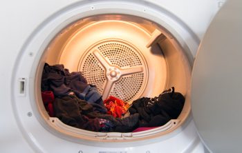 Interior View Of Typical Modern Domestic Tumble Dryer With Laundry In It.