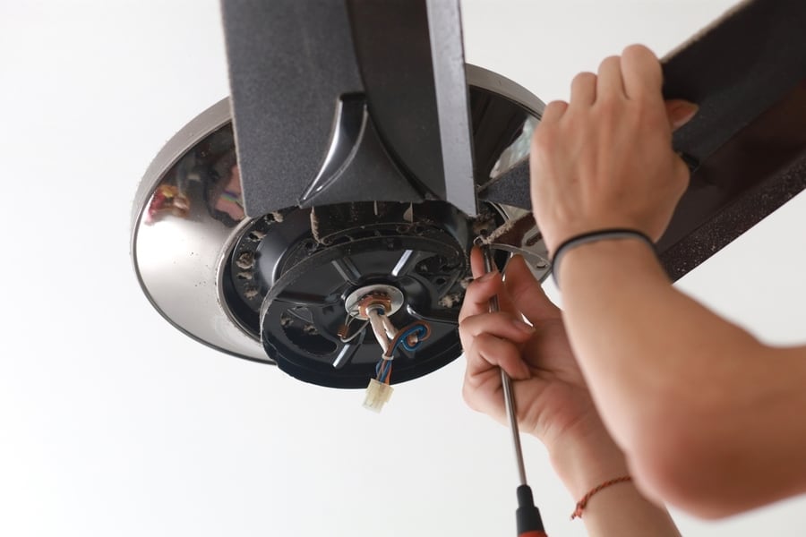 Male Electrician Fixing And Installing A Ceiling Fan In A House