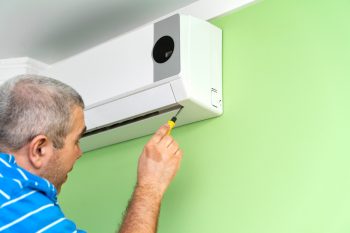 Male Technician Repairing And Diagnosing Air Conditioners