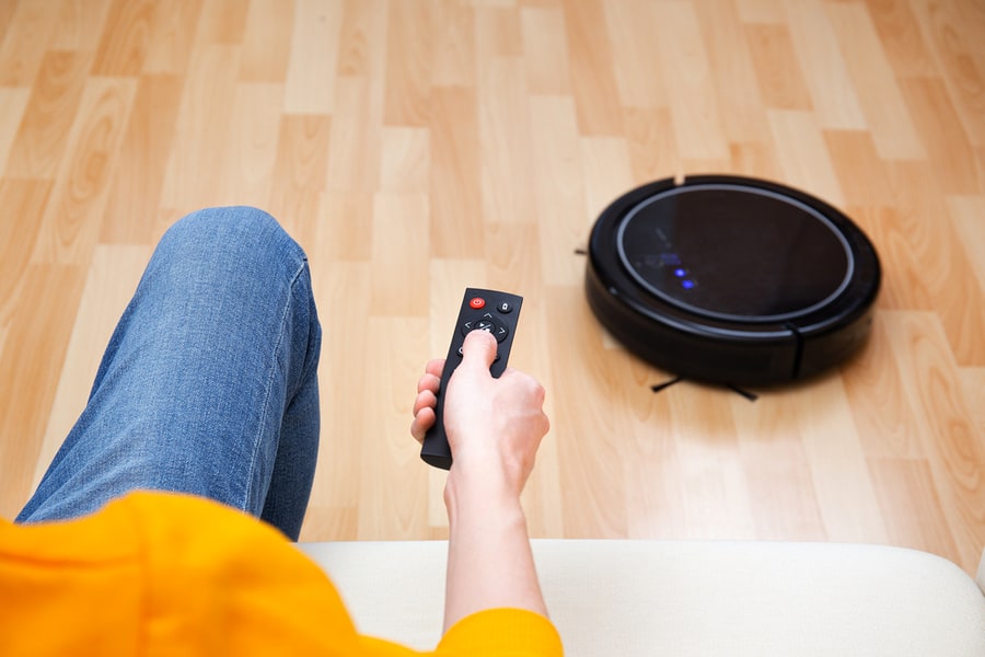 Man Resting While Robotic Vacuum Cleaner Doing Chores, Clean Work At Home