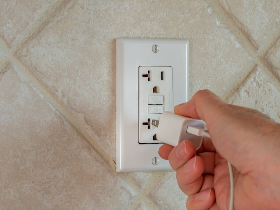 Plugging In Electrical Usb Cord And Charger Plug In Wall Outlet