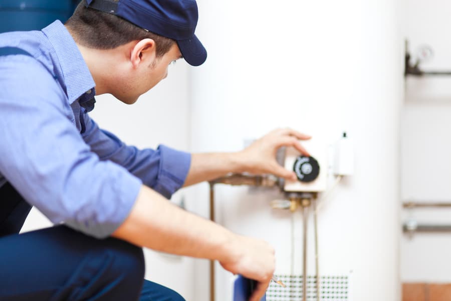 Plumber Adjusting The Hot-Water Heater