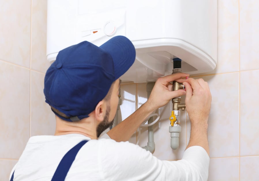Plumber Installing Water Heater In Bathroom