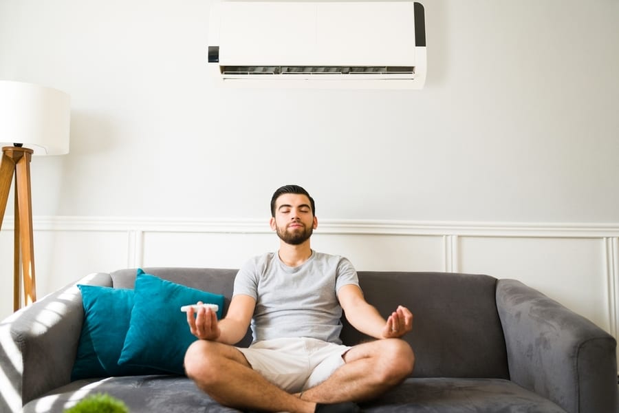 Relaxed Fit Man Doing A Meditation At Home And Enjoying The Cold Air Flow From The Air Conditioning