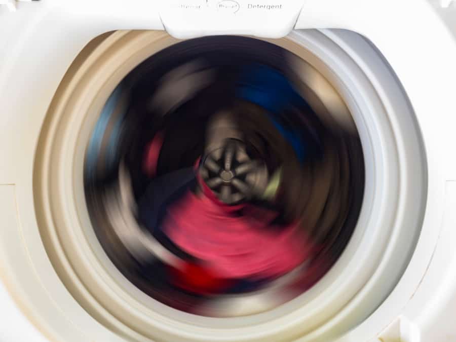 Top View Of A Washing Machine Drum During Spinning Clothes. Top Loading Washing Machine Washes Laundry.