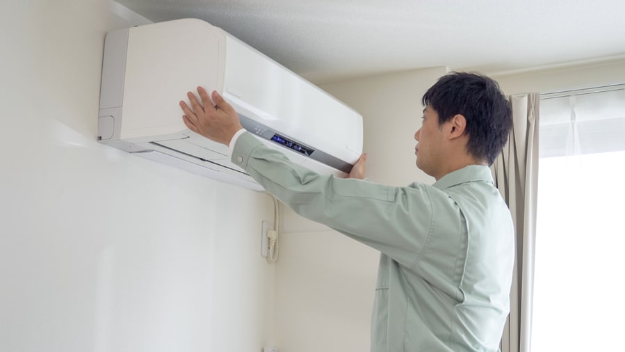 Worker Installing An Air Conditioner