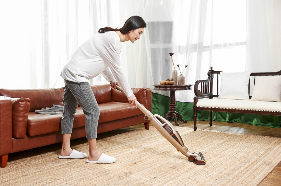 Young Asian Woman Use Wireless Vacuum Cleaner To Clean