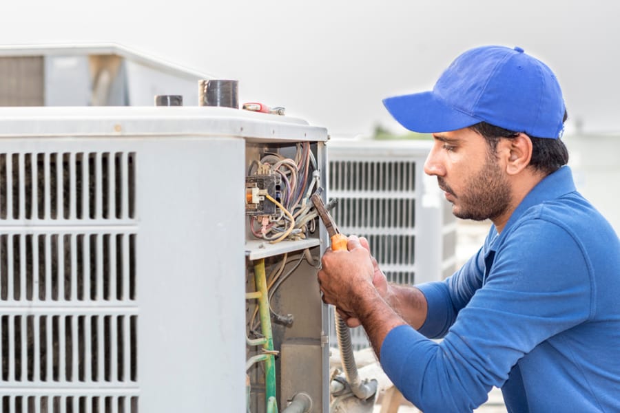 A Professional Electrician Man Is Fixing The Heavy Air Conditioner