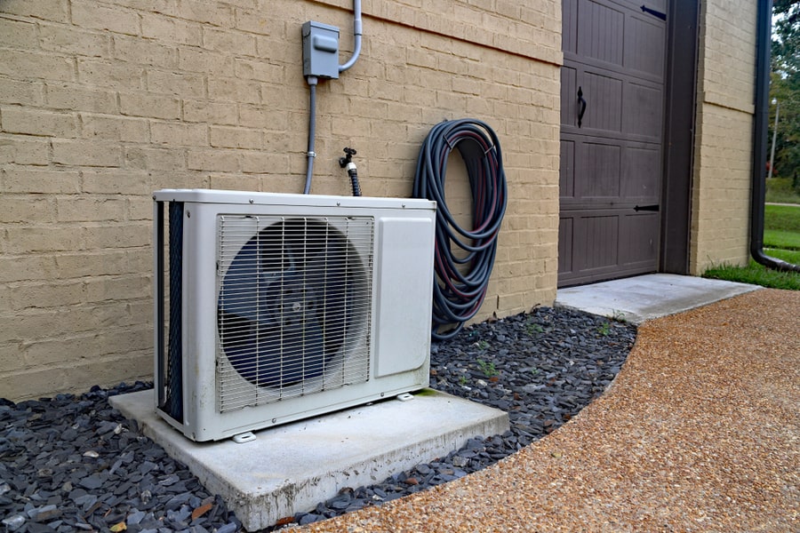 Air Conditioner Mini Split System Next To Home With Painted Brick Wall