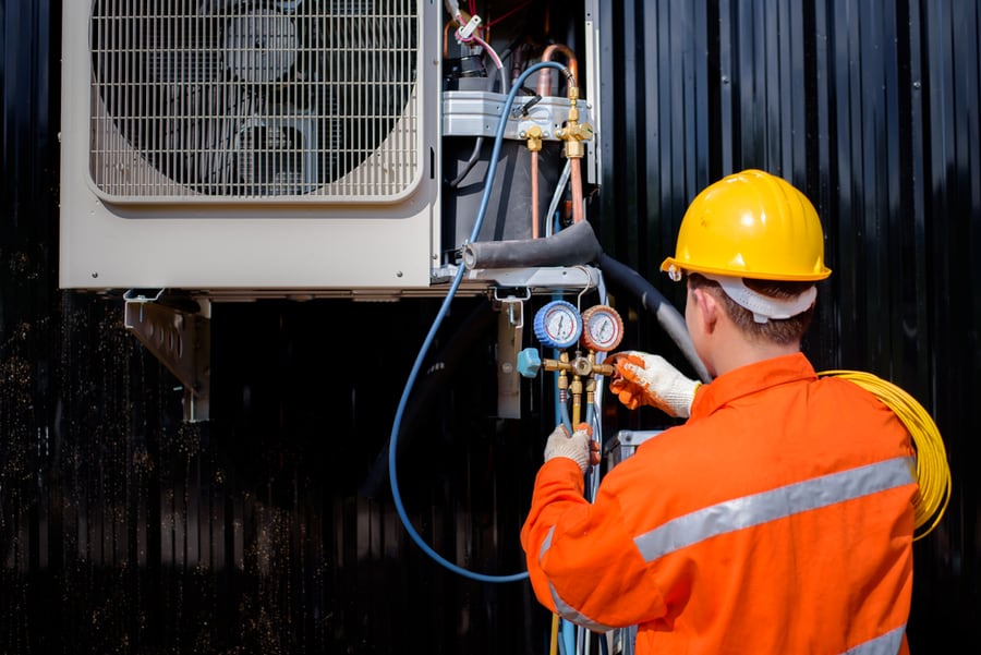 An Asian Male Air Technician Is Checking The Compressor And Filling It Up For Home