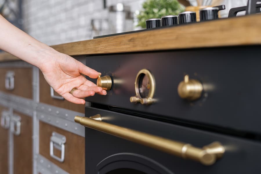 Cropped View Of Woman Hand Regulate Temperature And Timer On Built In Oven Equipment