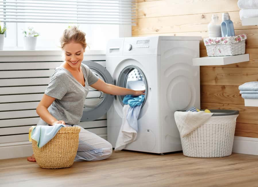 Housewife Woman In Laundry Room With Washing Machine