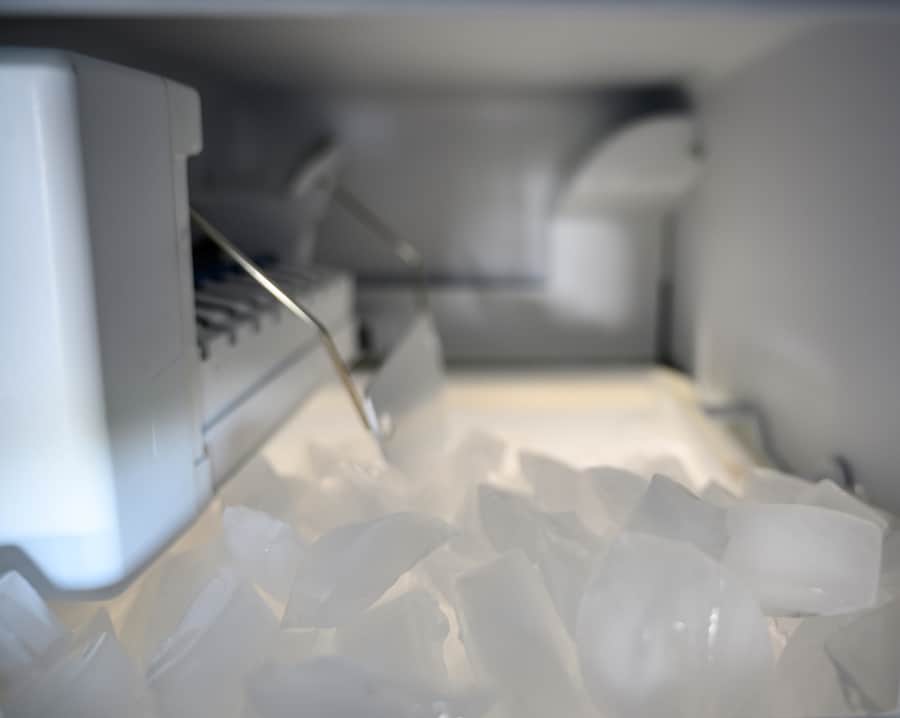 Inside A Freezer Automatic Ice Maker With Pile Of Cubes