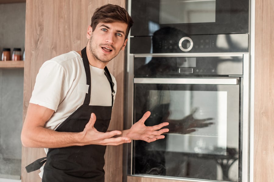 Man Standing Near Broken Oven On Home