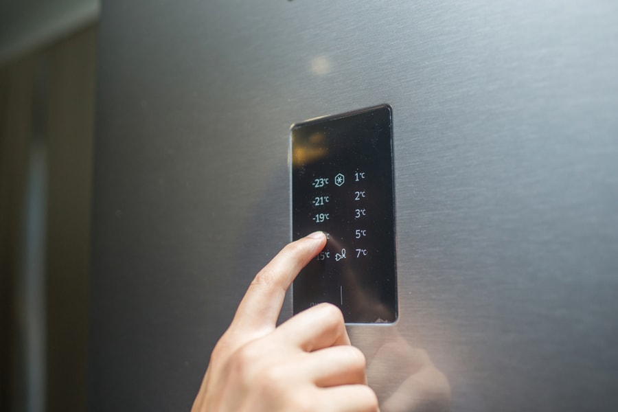 Man's Hand Regulates The Temperature Of The Refrigerator