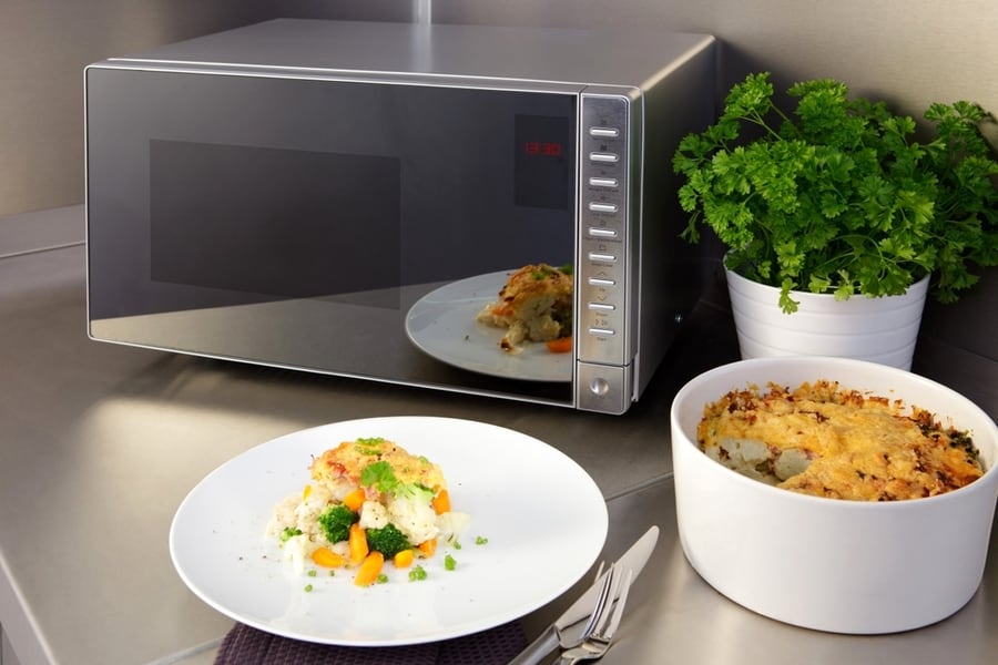 Microwave Oven With Food On The Kitchen Table