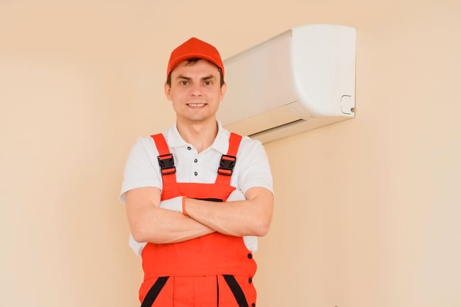 Portrait Of Young Smiling Man Professional Technician In Red Overall Fixing The Ac Air Conditioning