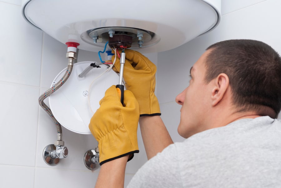 Repairman For An Electric Boiler Connects The Wires To A Thermostat