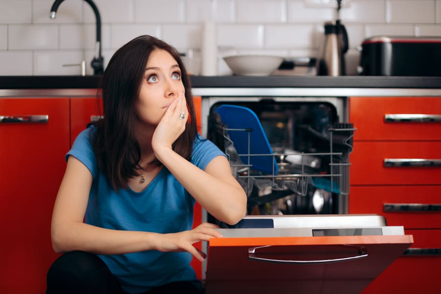 Sad Tired Woman Next To Full Dishwasher Cleaning Kitchen