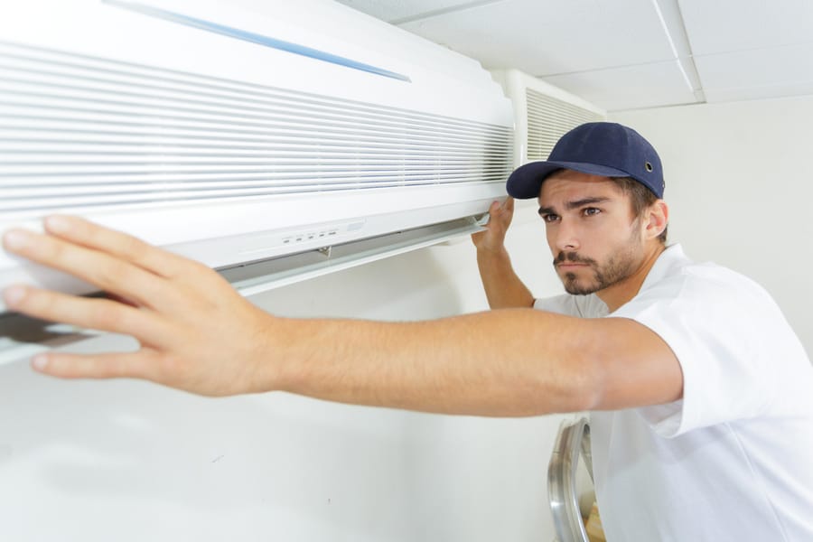 Tech Guy Carefully Installing New Ac