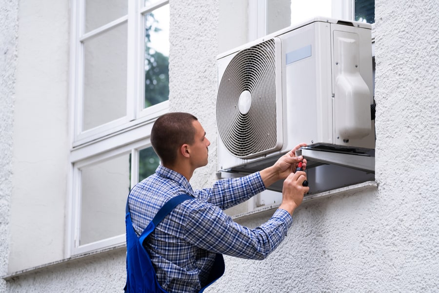 Technician Cleaning And Repairing Air Condition Appliance