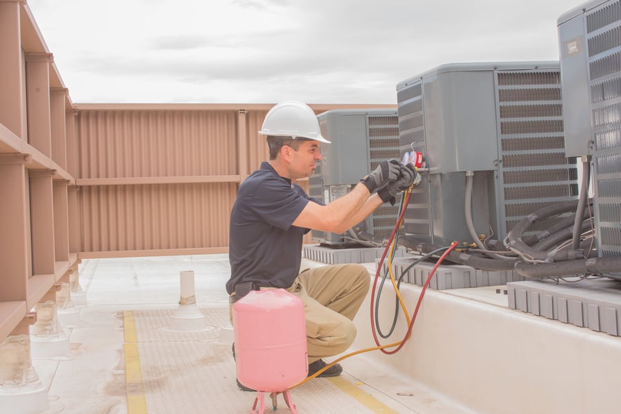 Technician Taking A Cover Plate Off An Air Conditioner Condenser