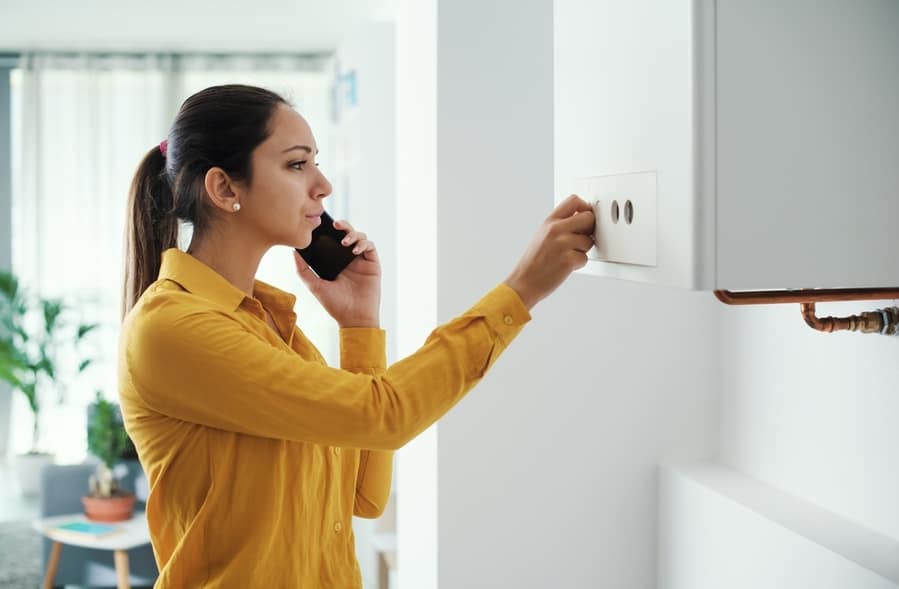 Worried Woman Calling A Boiler Breakdown Emergency Service Using Her Smartphone